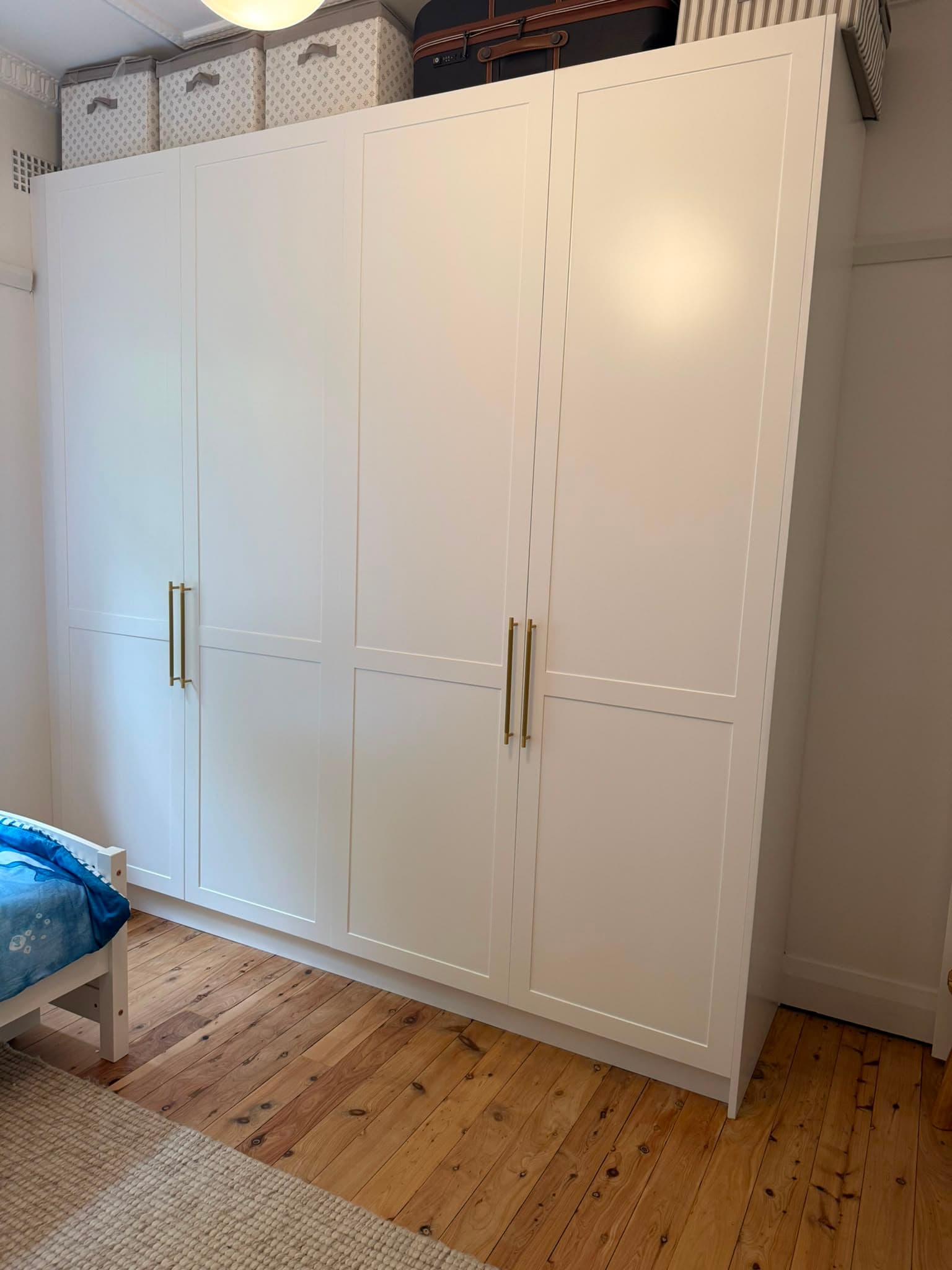 Four-door white shaker wardrobe with brass pull handles by A&E Joinery